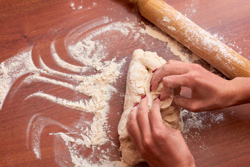 Dough for pizza. Rolling pin and dough on wooden background