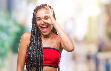 Sticker - Young braided hair african american with pigmentation blemish birth mark over isolated background doing ok gesture with hand smiling, eye looking through fingers with happy face.