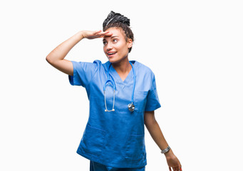 Sticker - Young braided hair african american girl professional surgeon over isolated background very happy and smiling looking far away with hand over head. Searching concept.