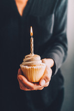 Woman Holding A Birthday Cupcake With Candle