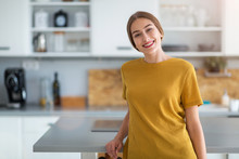 Young Woman Standing In The Kitchen