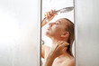 © amixstudio - Beautiful young european girl washes in the shower in the bathroom, enjoys with closed eyes