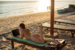 © Михаил Решетников - A young woman is lying with a laptop on a deckchair near the sea. work in travel. freelancer