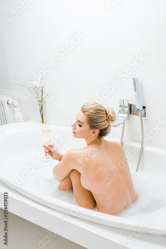 Beautiful And Naked Woman Taking Bath And Holding Champagne