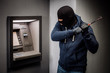 © kaninstudio - thief with crowbar opens the ATM.
