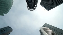 Time Lapse Down To Top Zoom Out Shot Of Top Skyscraper Forest Against Cloudy Daylight Sky, Silhouette Of Famous Banking And Office Towers From Frog Perspective