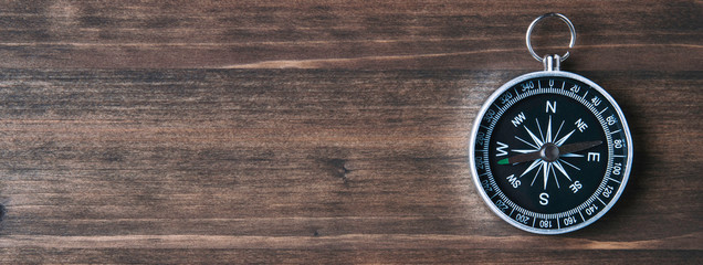 Wall Mural - Old compass on a dark wooden background. Copy space for text or design