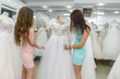 © RomanR - Saleswoman in wedding salon helping to young bride
