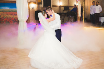 First wedding dance of newlywed couple in restaurant