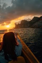 Poster - Woman travelers on boat in sea at sunset