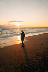 Wall Mural - Woman on sea beach at sunset