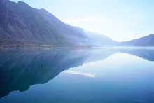 Morning In Boka Bay, Montenegro: High Mountains And Their Reflection In Calm Sea Water.