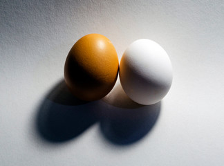 Poster - Blue eggs, brown eggs and duck eggs, whole and halves, in a pastel blue bowl on grey textured background. Top view.