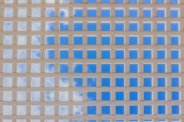 white iron grid industrial building object from below on bright blue sky background 