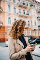 Wall Mural - Young woman wearing beige coat and hoodie