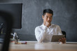 © mavoimages - Asian businessman sitting at his desk working on a tablet