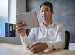© mavoimages - Young Asian businessman working on a tablet in an office