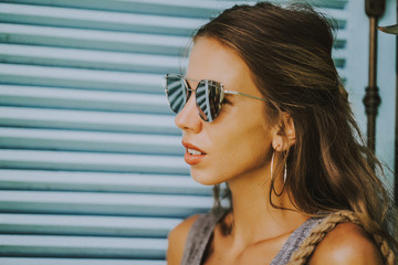 close-up portrait of a beautiful positive female in sunglasses smiling.