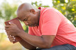 © digitalskillet1 - African American man praying and reading the Bible.