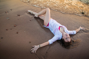 Girl rests and has fun in sea wave at sunset