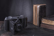 Zabytkowe, muzealne przedmioty na wystawie , ksiazki i analogowy aparat fotograficzna na klisze fotograficzne.