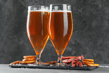  beer and appetizing beer snacks set. Table with mug of beer, wooden board with sausages