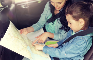 Poster - family, transport, road trip and people concept - happy woman and little daughter with map driving in car