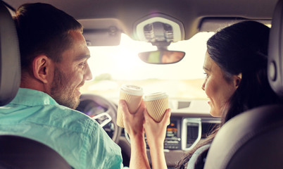 Sticker - leisure, road trip, travel, family and people concept - happy man and woman driving in car with coffee