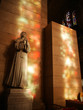 statue of a woman praying in the Notre Dame Cathedral. in multicolored highlights