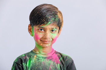 Indian little boy playing with the color and giving multiple expressions in holi festival 