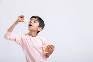 Cute indian/Asian little boy eating Mango with multiple expressions. isolated over white background