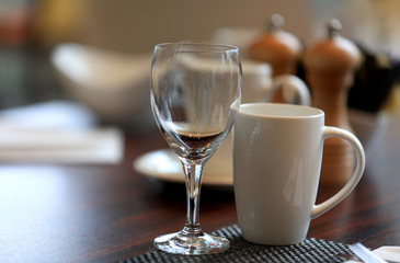 Wine glass and coffee cup on breakfast table