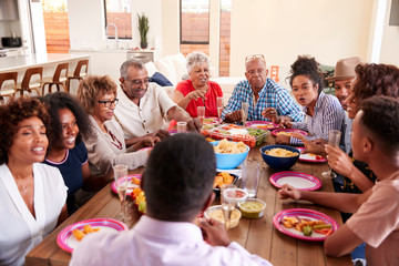 Three generation black family sitting at dinner table celebrating together,close up