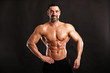 © Bas - Portrait of young handsome  muscular bodybuilder on black background