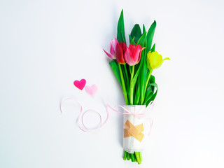  Tulpenstrauß mit Trostpflaster auf weißen Hintergrund, Liebeskummer, Frühling