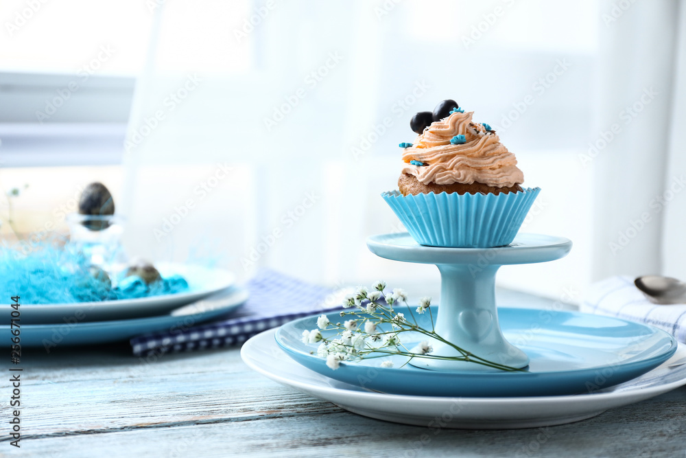 Tasty Easter cupcake on wooden table