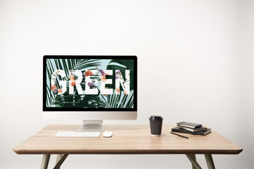 Wall Mural - computer with green leaves and green lettering on monitor on wooden desk