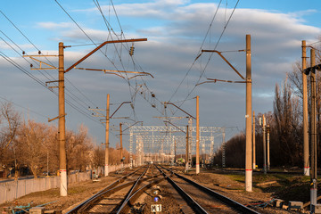 railway rails of the station in the evening in the light of the sun with a blue sky with clouds