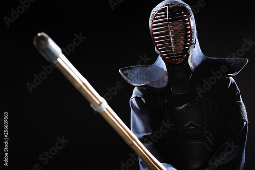 Dekoracja na wymiar  zawodnik-kendo-w-zbroi-cwiczacy-z-bambusowym-mieczem-na-czarnym-tle