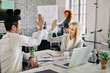 © Drazen - Happy business couple giving high-five to each other in the office.
