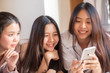 © themorningglory - Group of cheerful women using smartphone shopping online together