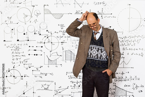 Fotomural Middle aged caucasian mathematician explaining equations on a white wall