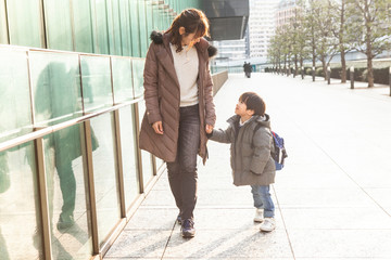 母と息子が仲良く手を繋いで歩いている