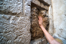 Close Up Of Young Man's Hand Touching An Old Square Stone With A Cavity Which Is Said To Be The Imprint Of Jesus Hand. Handprint Of Jesus At Station Five. Via Dolorosa, Jerusalem, Israel. Wall.
