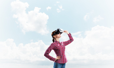 Canvas Print - Girl in checked shirt wearing VR glasses experiencing another reality