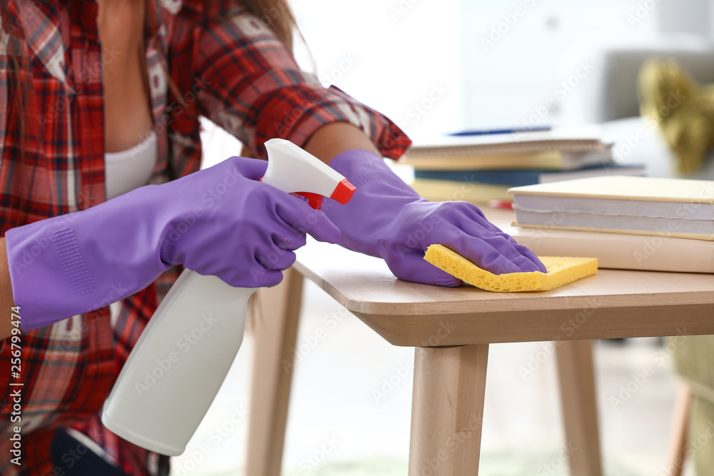Beautiful woman cleaning table at home, closeup