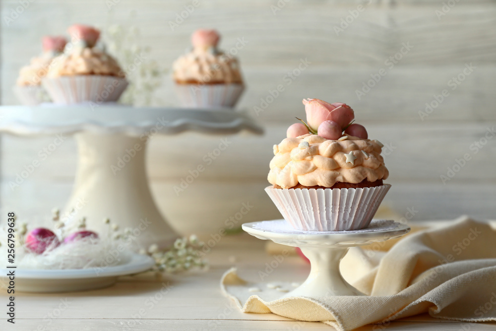 Dessert stand with tasty Easter cupcake on table