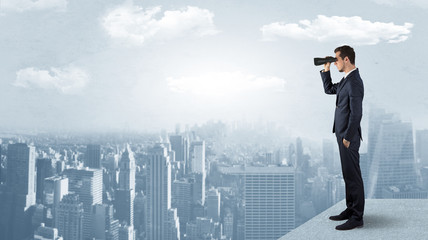 Wall Mural - businessman looking forward to a city with binoculars from skyscraper concept
