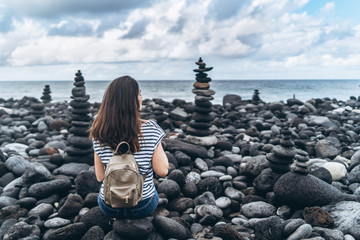 Wall Mural - Pretty brunette girl relaxing on the beach with stones.