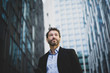 © ReeldealHD images - Businessman walking in city using smartphone